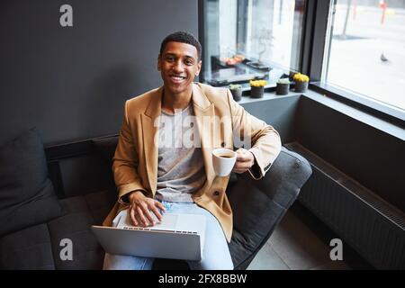 Junger dunkelhäutiger Mann, der direkt auf die Kamera schaut Stockfoto