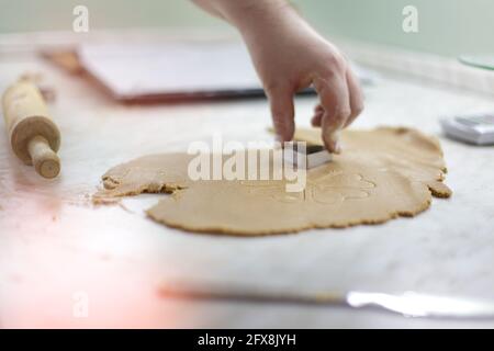 Frau schneidet in der Küche mit einem Ausstechform eine Daugh in Herzform Stockfoto