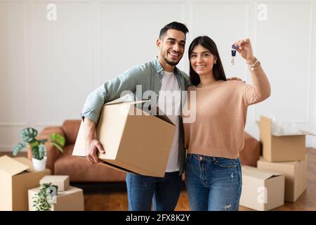 Glückliches Paar, das die Schlüssel ihrer Wohnung zeigte Stockfoto