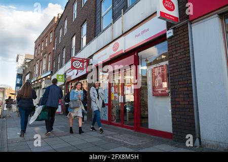 EPSOM, SURREY, Großbritannien - CIRCA FEB 2018: Zwei kaukasische junge Frauen, die vor einem örtlichen Postamt laufen Stockfoto