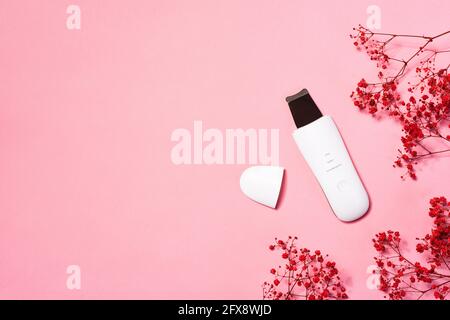 Ultraschall Wasser Peeling Home Gerät auf rosa Hintergrund. Gesichtsreinigung mit Ultraschallbehandlung, Hautpflege und Spa-Tools Stockfoto
