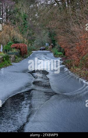 Regenwasser fließt die Trellech Straße hinunter in Richtung Tintern. Stockfoto