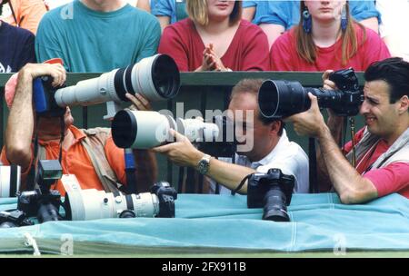 Professionelle Fotografen arbeiten auf Center Court bei Wimbledon Tennis Tournament 1990er Jahre. Sportfotografen Fotografie eng Squeeze überfüllt Großbritannien Stockfoto