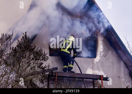 3. Dezember 2020, Dole Island, Lettland: Das Löschen des Feuers zerstörte das Dorfhaus Stockfoto