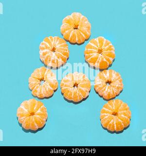 Kreatives Layout des BUCHSTABENS A aus geschälten Mandarinen auf blauem Hintergrund. Flatlay. Stockfoto