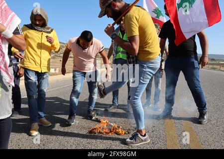 Naqoura, Libanon. Mai 2021. Libanesische und palästinensische Aktivisten stoßen am 25. Mai 2021 neben Naqoura, Libanon, die Reste der israelischen Flagge an der Grenze zwischen Libanon und Israel. Im Libanon wird der 25. Mai als Fest des libanesischen Widerstands und der Befreiung gefeiert, seit 2000, als die israelische Armee das Land verließ. (Foto: Elisa Gestri/Sipa USA) Quelle: SIPA USA/Alamy Live News Stockfoto