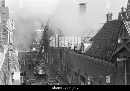 Feuer in der Werkstatt für Blinde auf der Amstel, die Feuerwehr, die das Feuer auslöschen, Menschen, die aus den Fenstern hängen, 20. Oktober 1964, FEUER, Fenster, Workshops, Niederlande, Foto der Presseagentur des 20. Jahrhunderts, zu erinnerende Nachrichten, Dokumentarfilm, historische Fotografie 1945-1990, visuelle Geschichten, Menschliche Geschichte des zwanzigsten Jahrhunderts, Momente in der Zeit festzuhalten Stockfoto