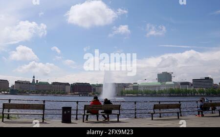 Hamburg, Deutschland. Mai 2021. Die Menschen sitzen auf Bänken und genießen das sonnige Wetter an der Binnenalster. Kredit: Marcus Brandt/dpa/Alamy Live Nachrichten Stockfoto