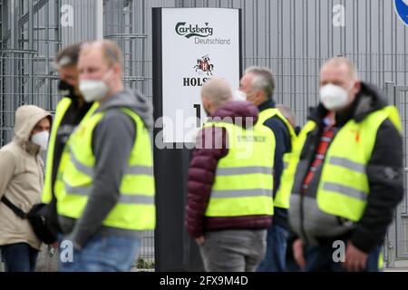 Hamburg, Deutschland. Mai 2021. Streikende stehen vor einer Carlsberg Deutschland Brauerei in Hamburg-Hausbruch. Im Lohnstreit bei norddeutschen Brauereien hat die Gewerkschaft NGG Beschäftigte in Bremen, Hamburg, Flensburg und Lübz zu Warnstreiks aufgefordert. Die Arbeitskampfmaßnahme sollte am Mittwoch Mittag mit der Spätschicht beginnen und 24 Stunden dauern. Kredit: Bodo Marks/dpa/Alamy Live Nachrichten Stockfoto