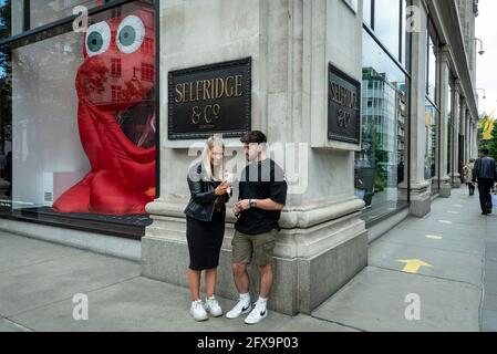 London, Großbritannien. 26 Mai 2021. Ein Paar vor einem riesigen animierten Charakter, der die Marke Dior promotet und ein Schaufenster im Kaufhaus Selfridge & Co in der Oxford Street füllt. Kredit: Stephen Chung / Alamy Live Nachrichten Stockfoto