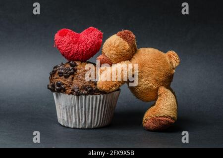 teddybär mit Schokoladenmuffins und Herz Stockfoto