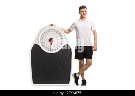 Porträt eines jungen Mannes in Sportswear-Posen Neben einer großen Skala isoliert auf weißem Hintergrund Stockfoto