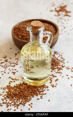 Rohe Leinsamen Öl und Samen mit einem Löffel auf Nahaufnahme des weißen Tisches Stockfoto
