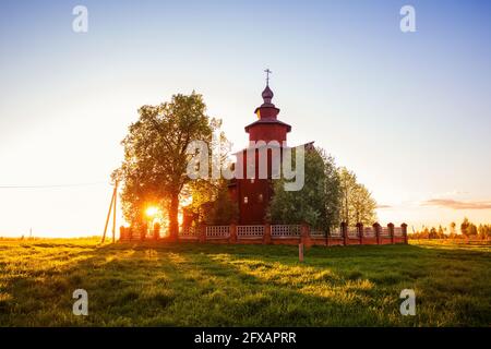 Alte ländliche Holzkirche des Theologen Johannes am Fluss Ishnya. Frühlingslandschaft bei Sonnenuntergang. Jaroslawl-Region, Goldener Ring Russlands. Stockfoto