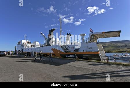 Passagiere steigen von der Baldur-Fähre aus, deren Hecklandungsrampe hochgezogen ist, im Hafen von Stykkisholmur im Westen Islands, am 7. Juli 2016 Stockfoto