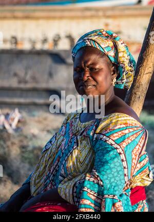 Senegal, Afrika - Jan, 2019: Porträt einer schönen senegalesischen Frau in einem traditionellen Kostüm namens "boubou" und eine Schaukel auf dem Kopf Stockfoto