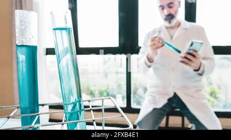 Reagenzgläser mit Flüssigkeit und Wissenschaftler mit Labormantel in einem wissenschaftlichen Labor. Baskenland, Spanien, Europa. Stockfoto