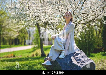 Eine Frau in einem blühenden Garten. Zartes Foto mit weißen Blüten im Frühjahr Stockfoto