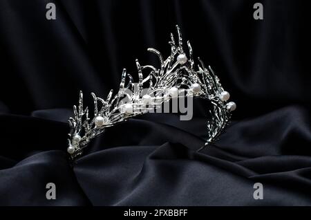 Tiara mit Perlen isoliert auf einer schwarzen Seide Stockfoto