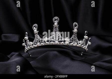 Tiara mit Perlen isoliert auf einer schwarzen Seide Stockfoto