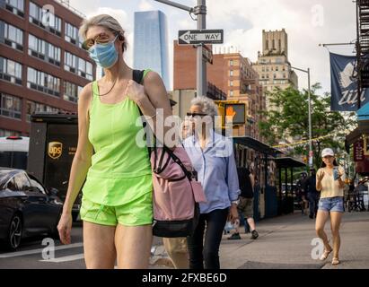 Maskierte und maskenlose Menschen in Chelsea in New York am Dienstag, den 18. Mai 2021. New York hat entspannte Maskenmandate, die es den meisten Outdoor-Aktivitäten erlauben, maskenfrei zu sein, sowie viele Innenräume, mit Einschränkungen. (© Richard B. Levine) Stockfoto