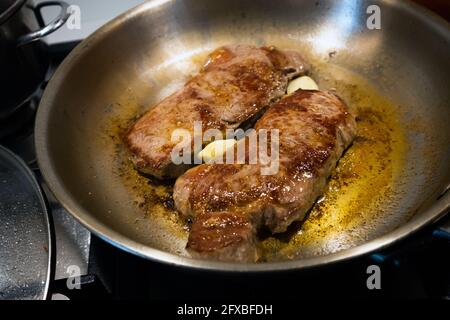 Anbraten von Rindersteak in einer Edelstahlpfanne. Stockfoto