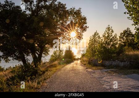 Leere Straße mit Sonnenuntergang über der Adria in Omis, Dalmatien, Kroatien Stockfoto