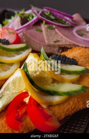 Smorrebrod ein traditionelles dänisches offenes Sandwich, das aus einem Stück dunklem Roggenbrot besteht, gekrönt mit Aufschnitt, Fleisch- oder Fischstücken, Käse oder Spr Stockfoto