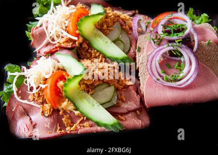 Smorrebrod ein traditionelles dänisches offenes Sandwich, das aus einem Stück dunklem Roggenbrot besteht, gekrönt mit Aufschnitt, Fleisch- oder Fischstücken, Käse oder Spr Stockfoto