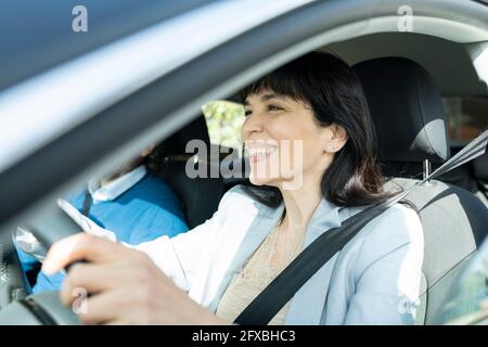 Lächelnder, reifer Unternehmer, der Auto fährt Stockfoto