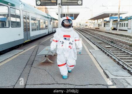 Weibliche Astronautin im Raumanzug zu Fuß auf dem Bahnhof Stockfoto