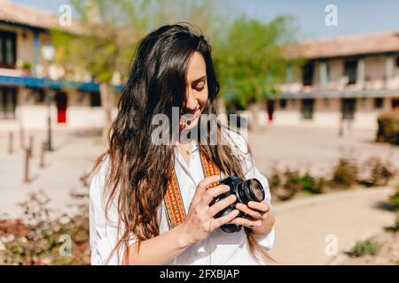 Lächelnde Frau mit Kamera am sonnigen Tag Stockfoto