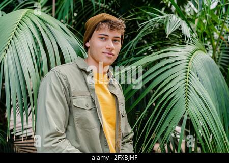 Lächelnder junger Mann mit Strickmütze, der im Park steht Stockfoto