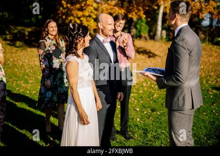 Glückliches Paar, das den Hochzeitsplaner ansieht Stockfoto