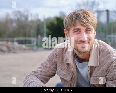 Bärtig schöner Mann lächelt, während er Freizeit im Freien verbringt Stockfoto