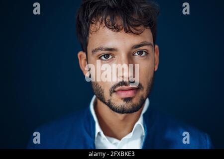 Hübscher junger Mann vor blauem Hintergrund Stockfoto