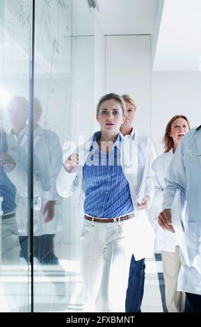 Weibliche und männliche Ärzte, die während der Dringlichkeit im Krankenhaus herunterlaufen Stockfoto