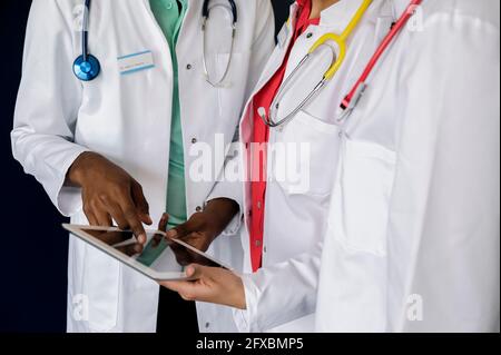 Ein Arzt diskutiert über ein digitales Tablet mit weiblichen Kollegen im Krankenhaus Stockfoto