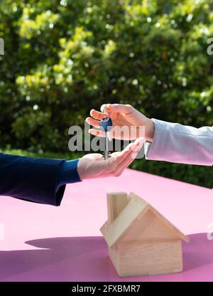 Immobilienentwickler, der Kunden am sonnigen Tag Hausschlüssel gibt Stockfoto