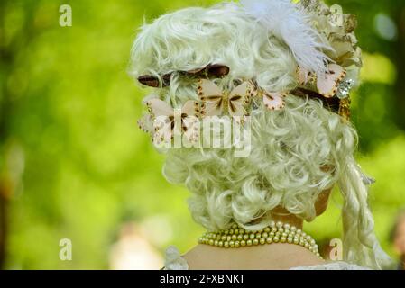 Schöne Frau im mittelalterlichen Kleid. rokoko alte Frisur mit Butterfyis in blonden Frauenhaaren Stockfoto