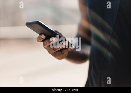 Mann, der im Freien mit einem Mobiltelefon telefoniert Stockfoto