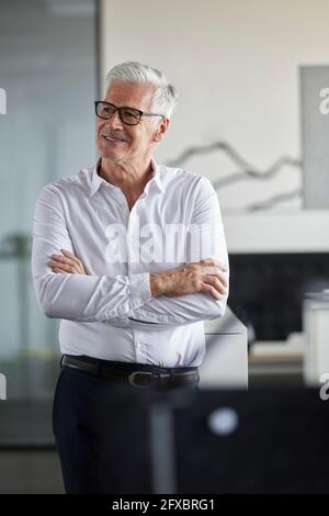 Reifer Unternehmer schaut weg, während er im Büro nachdenkt Stockfoto