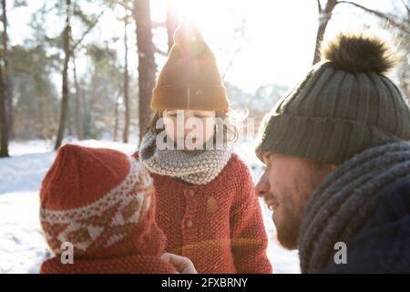 Vater spricht im Winter mit Söhnen Stockfoto
