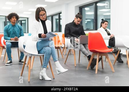 Geschäftsleute, die während der Konferenz im Schulungsraum sitzen Stockfoto