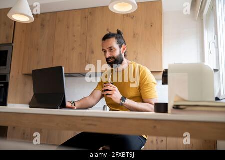 Reifer Mann, der zu Hause Tablet-PC verwendet Stockfoto