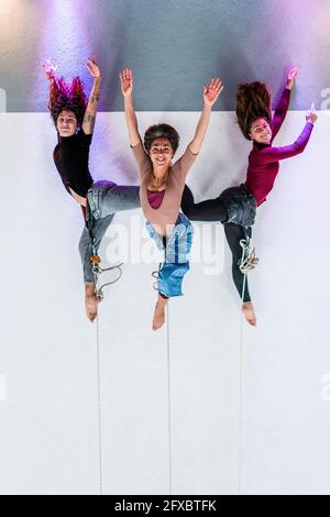 Tänzerinnen, die akrobatische Aktivitäten ausüben, während sie im Tanzstudio am Seil hängen Stockfoto