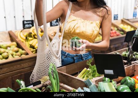 Frau kauft grüne Paprika im Supermarkt Stockfoto