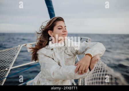 Mutter und Tochter, die während ihres Urlaubs auf dem Segelboot im Meer unterwegs waren, schauten sich die Aussicht an Stockfoto