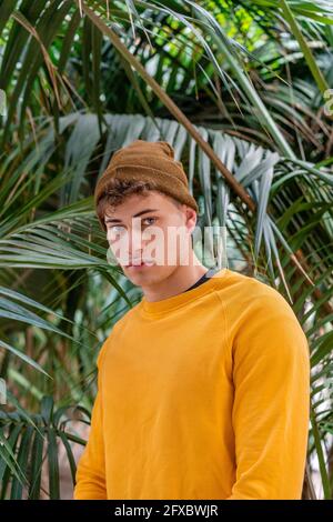 Junger Mann mit Strickmütze, der im Park steht Stockfoto