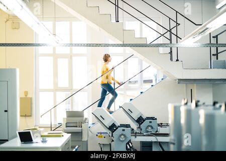 Unternehmerin auf den Stufen in der Druckerei Stockfoto